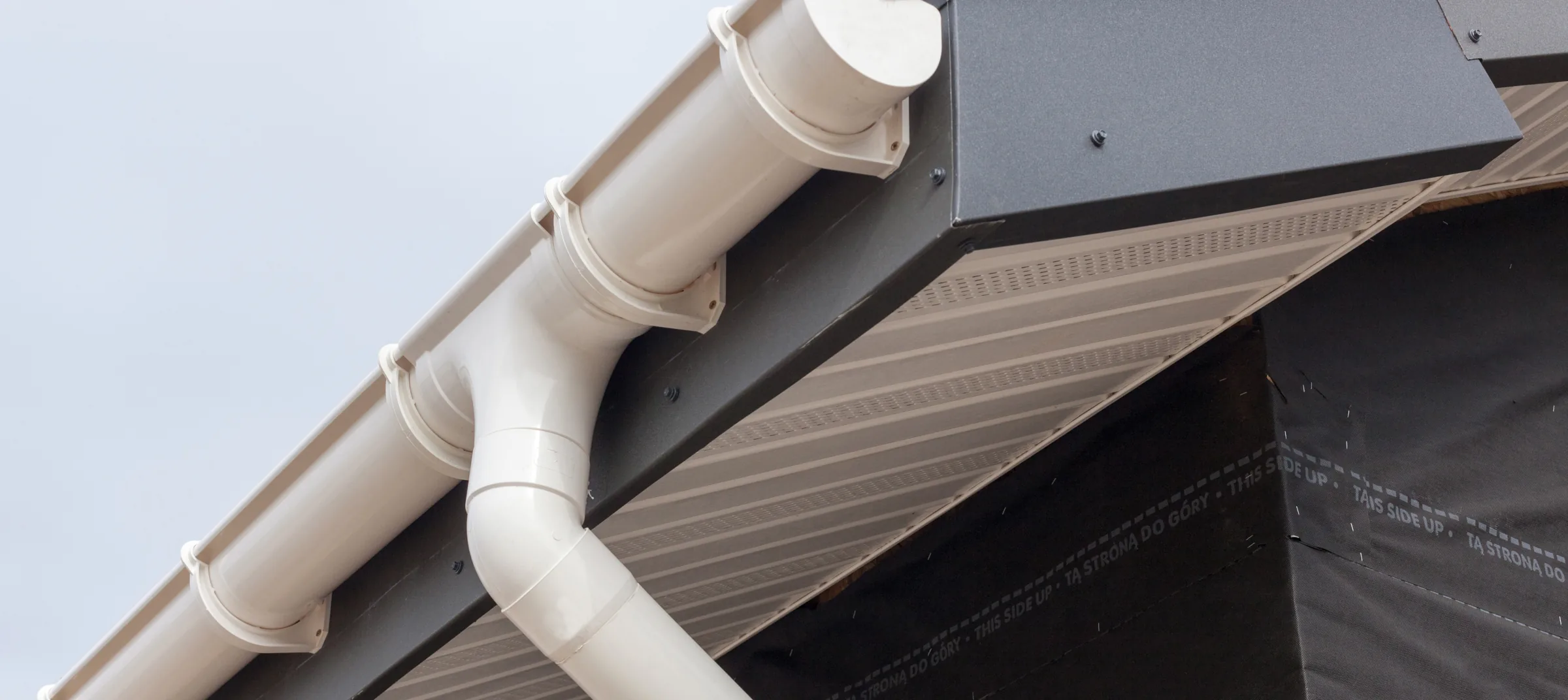 PVC rainwater gutter and downpipe on a building eave